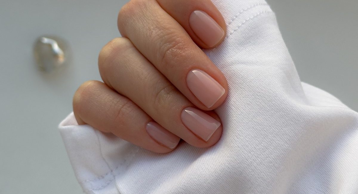 Доглянуті руки з прозорим нюдовим покриттям, що виглядає охайно
