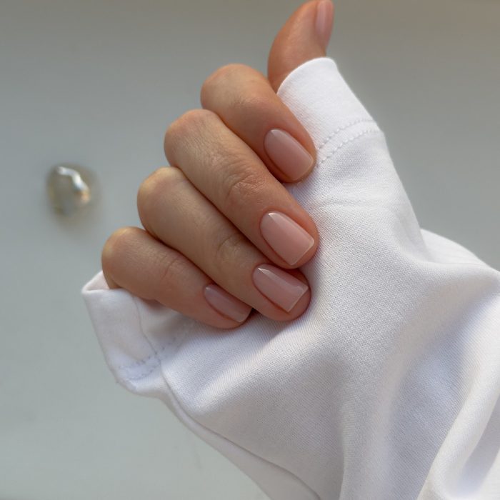 Доглянуті руки з прозорим нюдовим покриттям, що виглядає охайно